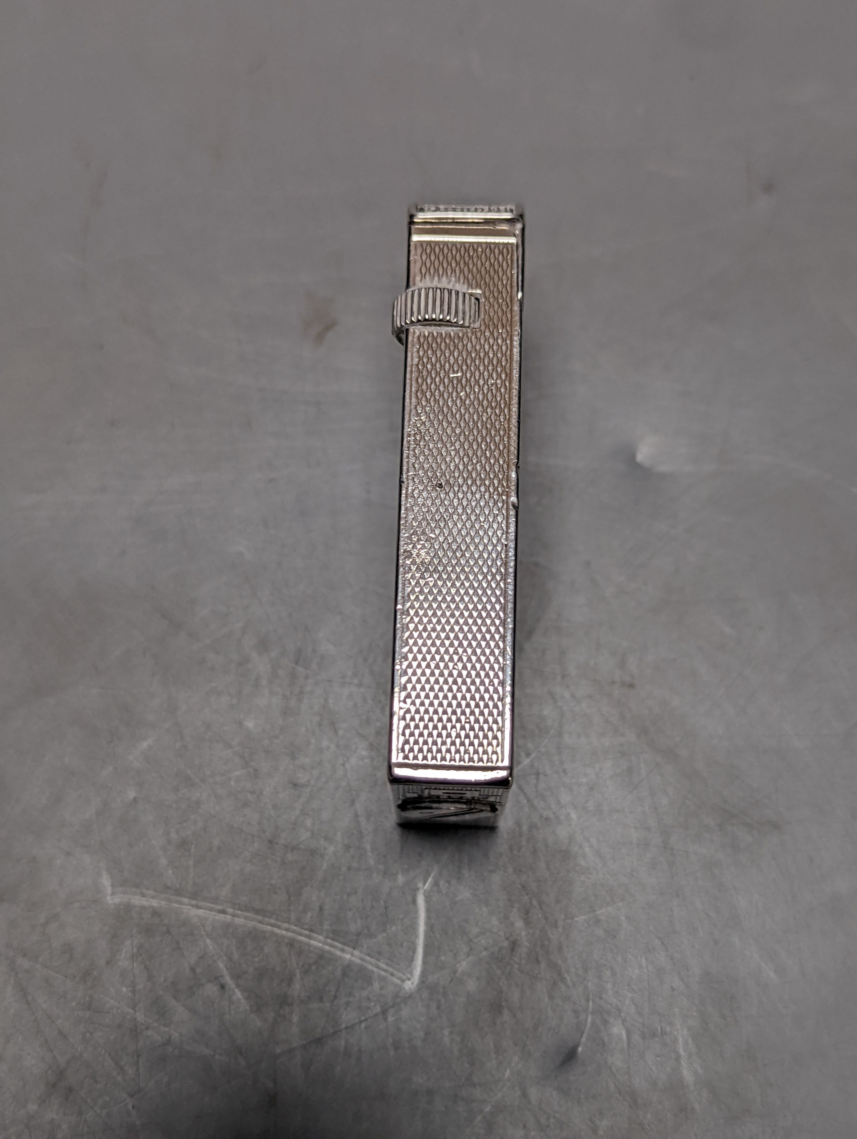 A George VI engine turned silver mounted Dunhill lighter, London, 1945, 57mm.